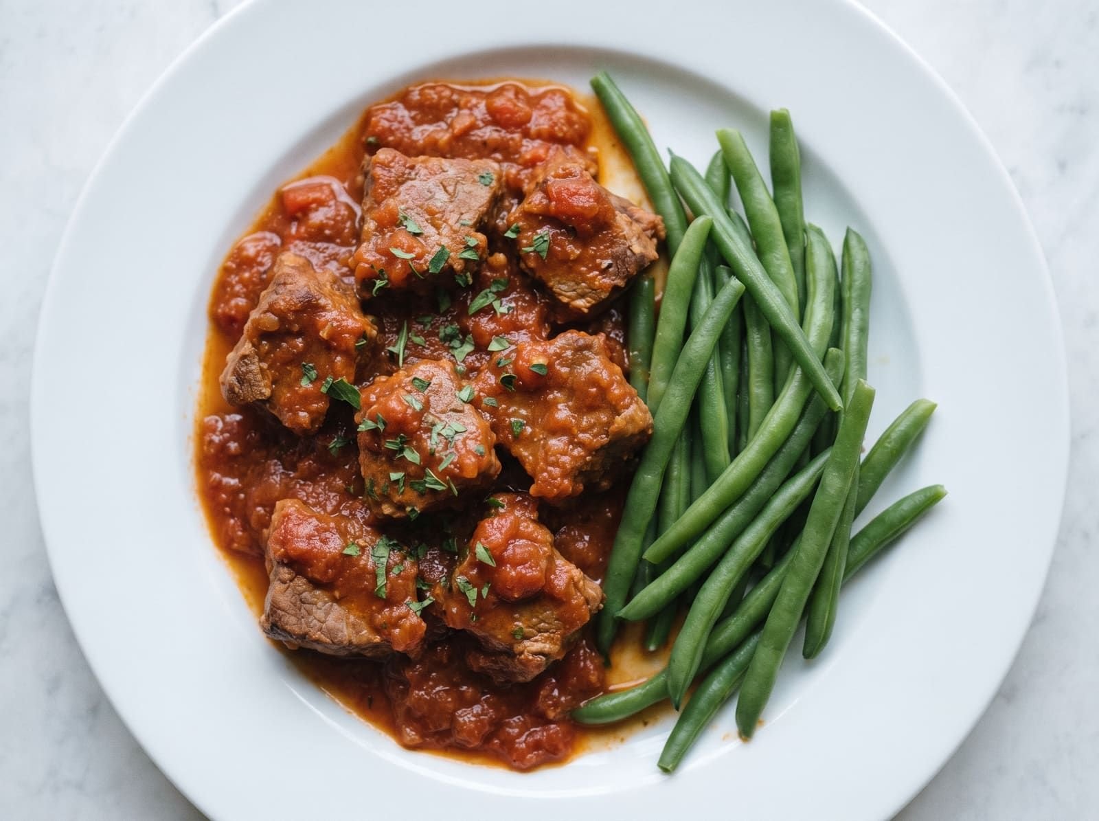 Veau à la tomate, accompagné de haricots verts